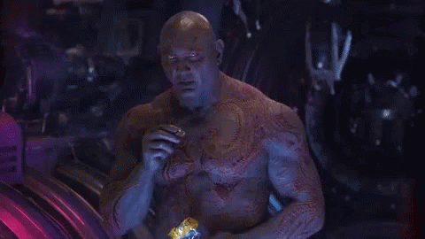 Bald Man With Chest Tattoo Sitting in Dark Room
