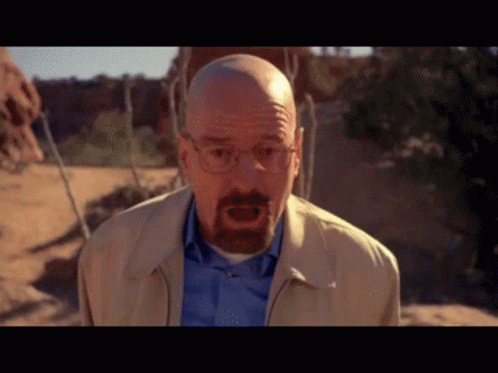 Bald Man With Glasses and Beard in Tan Jacket and Blue Shirt
