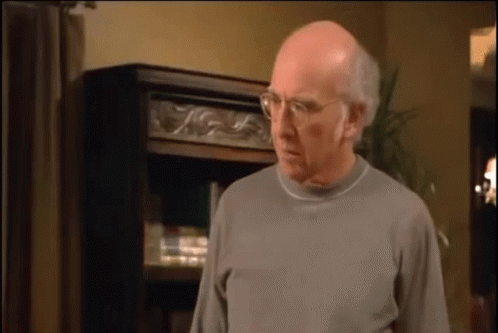 Bald Man with Glasses and Gray Sweater Bookshelf