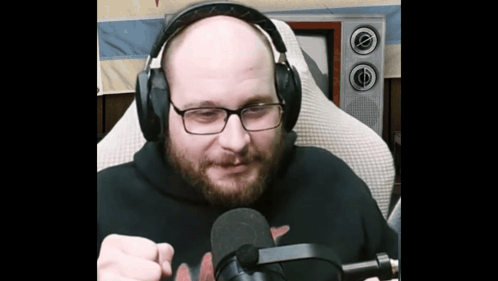 Bald Man with Glasses and Headphones Holding Microphone
