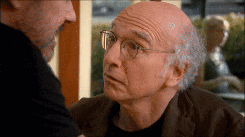 Bald Man With Glasses Talking to Another Bald Man