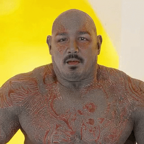 Bald Man With Mustache and Chest Tattoo