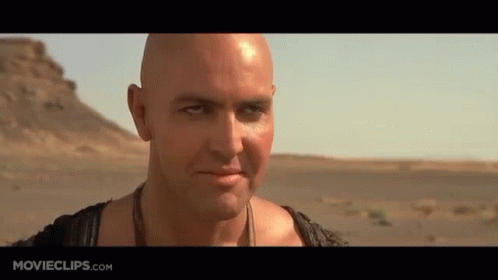 Bald Man With Necklace in Desert
