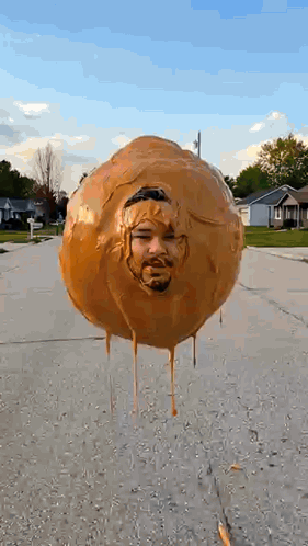 Balloon With Man's Face Floating Above Street GIF
