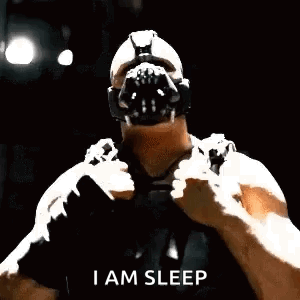 Bane From The Dark Knight Rises Is Wearing A Gas Mask And Holding A Sword . GIF