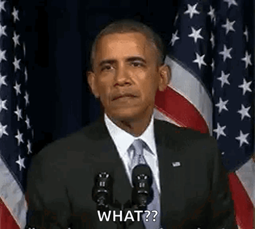 Barack Obama Is Giving A Speech In Front Of An American Flag While Standing In Front Of A Microphone . GIF