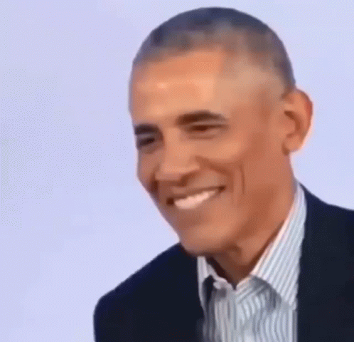 Barack Obama Is Smiling While Wearing A Suit And A Striped Shirt . GIF