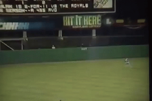 Baseball Game in Front of Hit It Here Sign