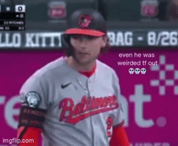 Baseball Player in Baltimore Jersey in Front of Pink Sign