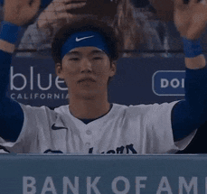 Baseball Player in Dugout With Bank of Fame Sign