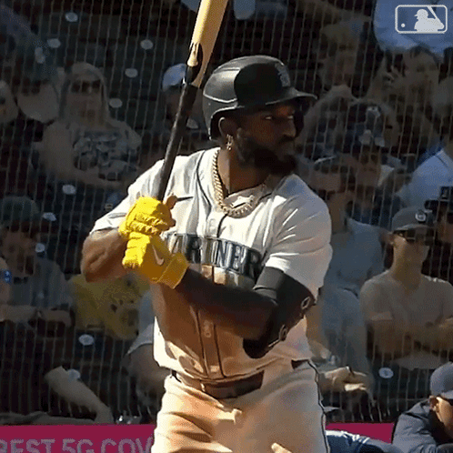 Baseball Player in Mariners Jersey Swinging Bat