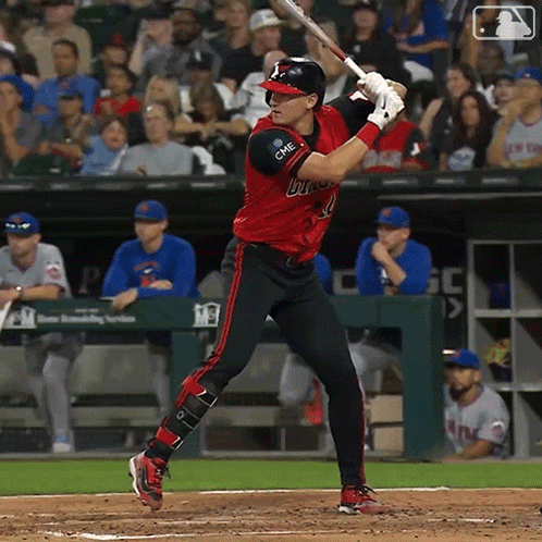 Baseball Player in Red and Black Bulls Uniform Swinging at Pitch