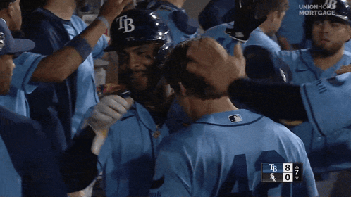 Baseball Player In TB Hat Surrounded By Teammates GIF