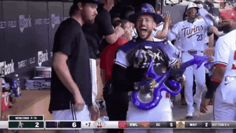 Baseball Player in Twins Jersey Holding Blue Balloon