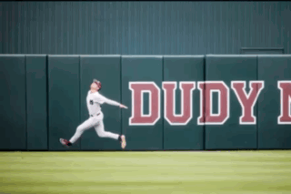 Baseball Player Jumps for Ball Near Dudy Wall