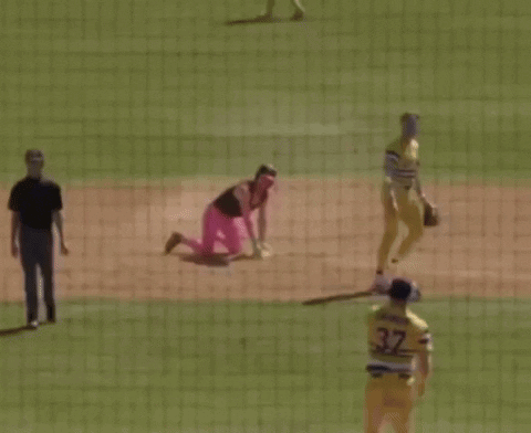Baseball Player Kneeling in Pink Pants and Helmet