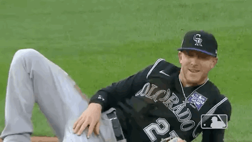 Baseball Player Laying on Field With Legs Crossed