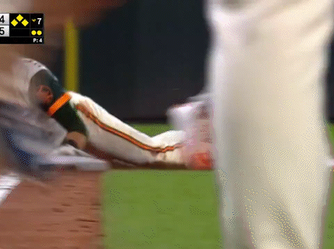 Baseball Player Laying on Ground With Scoreboard Saying 7