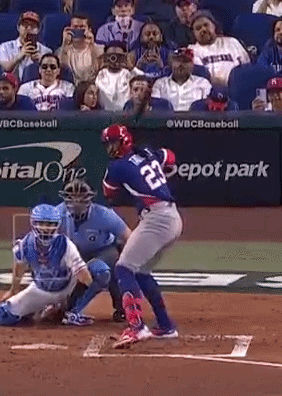 Baseball Player Number 23 Swinging at Ball