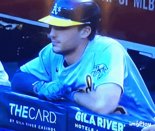 Baseball Player Sitting in Dugout with The Card Sign
