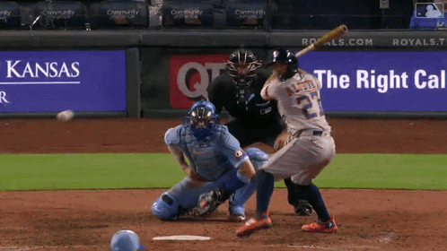Baseball Player Swinging at Ball in Front of Kansas Ad
