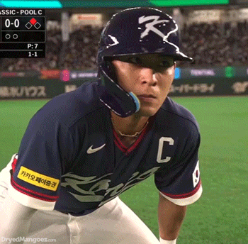 Baseball Player Swinging Bat in Front of Yankees Sign