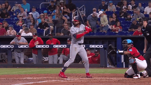 Baseball Player Swinging Bat With Geico Banner GIF