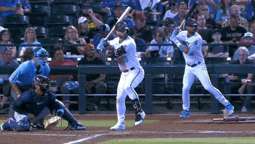 Baseball Player Swinging While Another Watches GIF