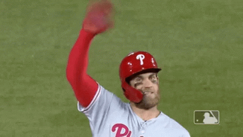 Baseball Player Waving Hand in Red Helmet