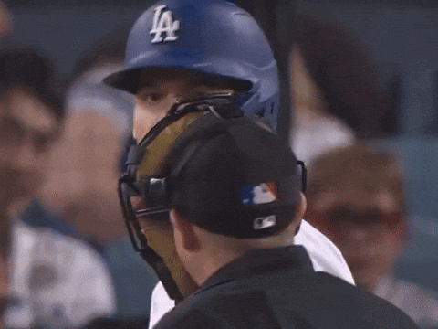 Baseball Player Wearing Helmet Talking to Umpire