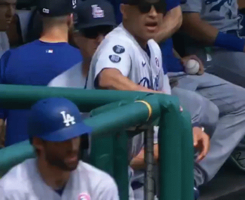 Baseball Player Wearing LA Hat in Dugout