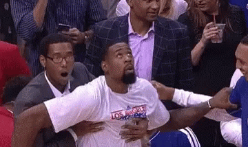 Basketball Player Held by Men in Crowd