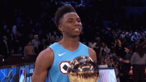 Basketball Player in Blue Jersey Holding Trophy