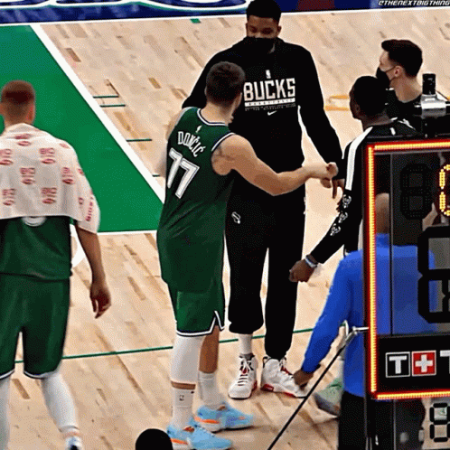 Basketball Player in Bucks Jersey Shaking Hands With Referee