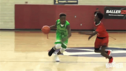Basketball Player in Green Dribbling Past Red Player