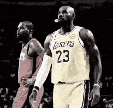 Basketball Player in Lakers Jersey Standing Next to Another Player
