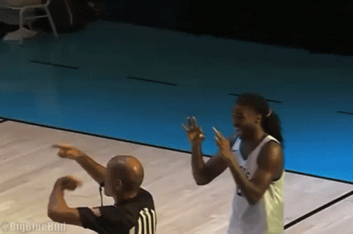 Basketball Player Pointing at Referee in Blue