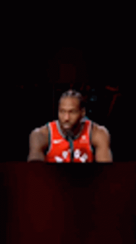 Basketball Player Sitting at Table in Dark Room