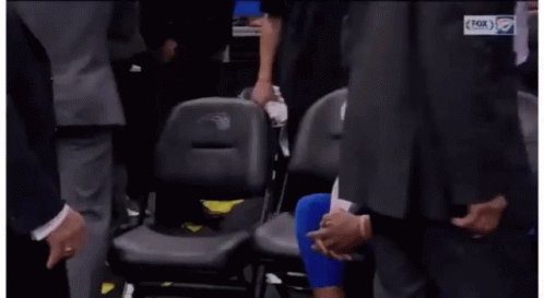 Basketball Player Sitting in Stands With Hands Folded