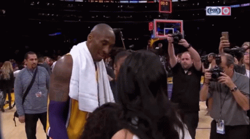 Basketball Player With Towel Talks To Woman At Fox Sports Scoreboard GIF