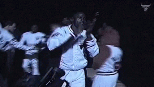 Basketball Players Dancing In Dark Room With Bull Logo GIF
