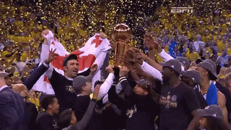 Basketball Players Holding Trophy in Crowd