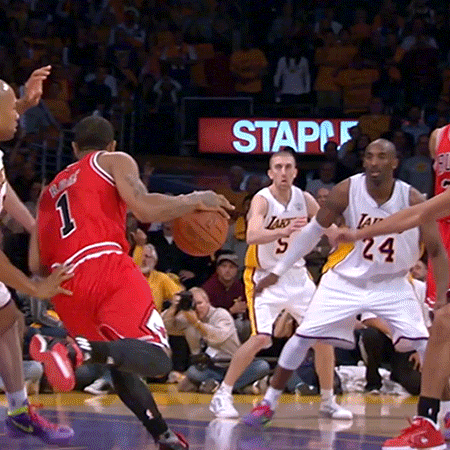 Basketball Players On A Court With A Staples Sign Behind Them GIF
