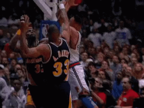 Basketball Players Playing in Front of Crowd