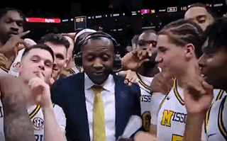 Basketball Players Posing With Man in Headphones