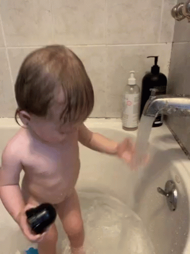 Kid Plays Water During Bath Time GIF