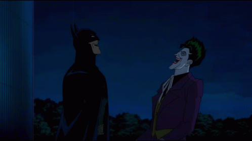 Batman And The Joker Standing Next To Each Other At Night GIF