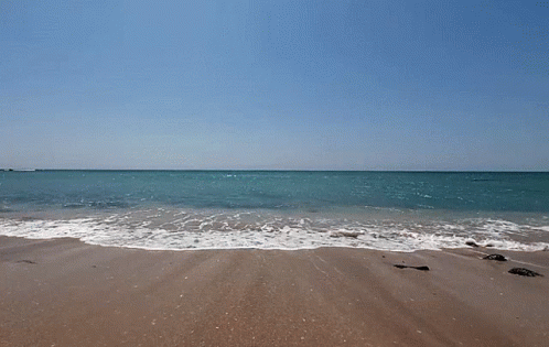 Beach with Waves Crashing and Blue Sky