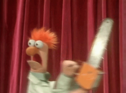 Beaker From The Muppet Show Is Holding A Chainsaw In Front Of A Red Curtain . GIF