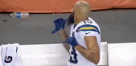 Bearded Football Player In Locker Room With Gloves GIF